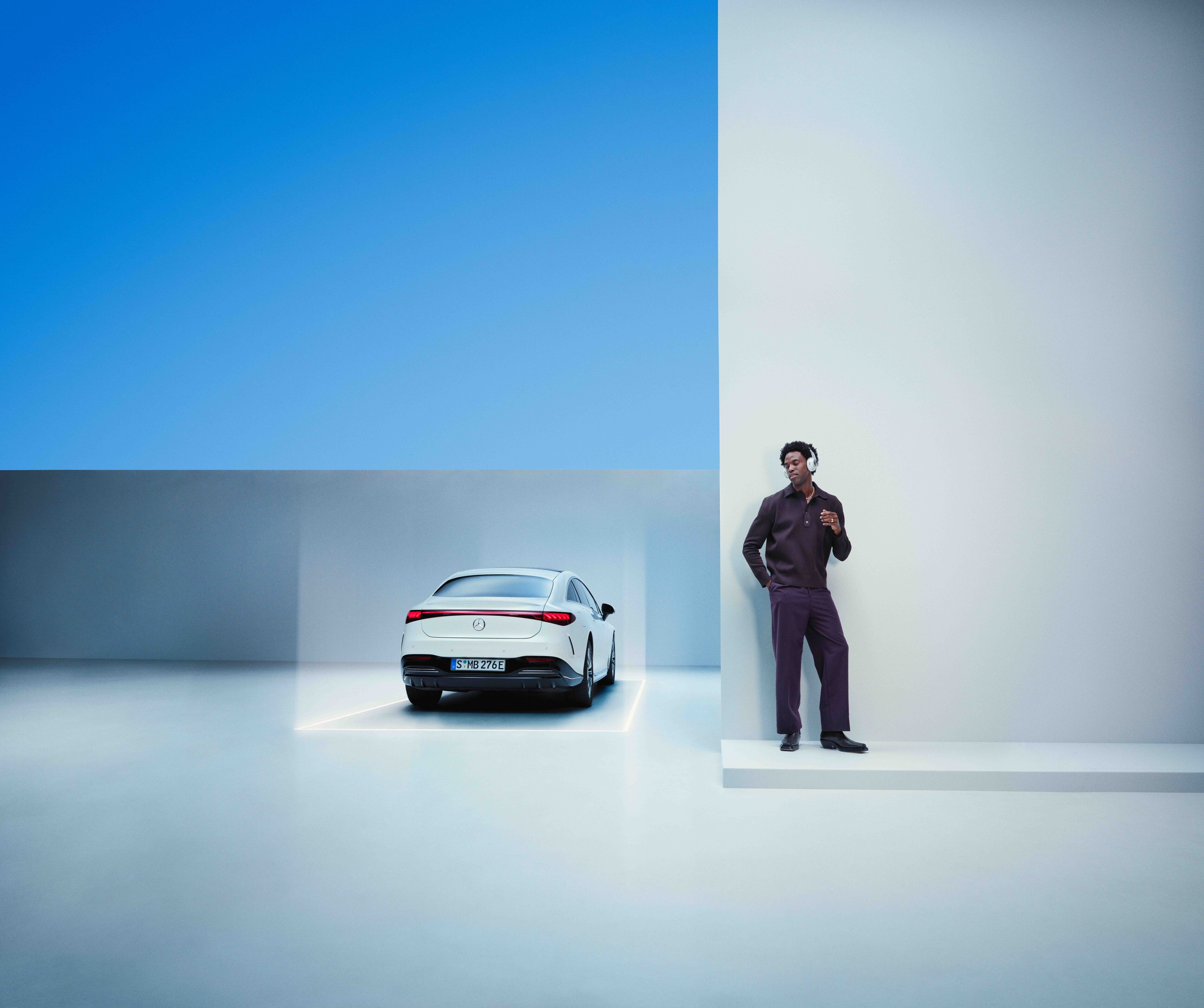 Gute Fahrt mit der Mercedes-Benz Neufahrzeug-Garantie. Eine entspannter Mann steht mit Kopfhörern an eine Wand gelehnt. Daneben ist ein Mercedes zu sehen.