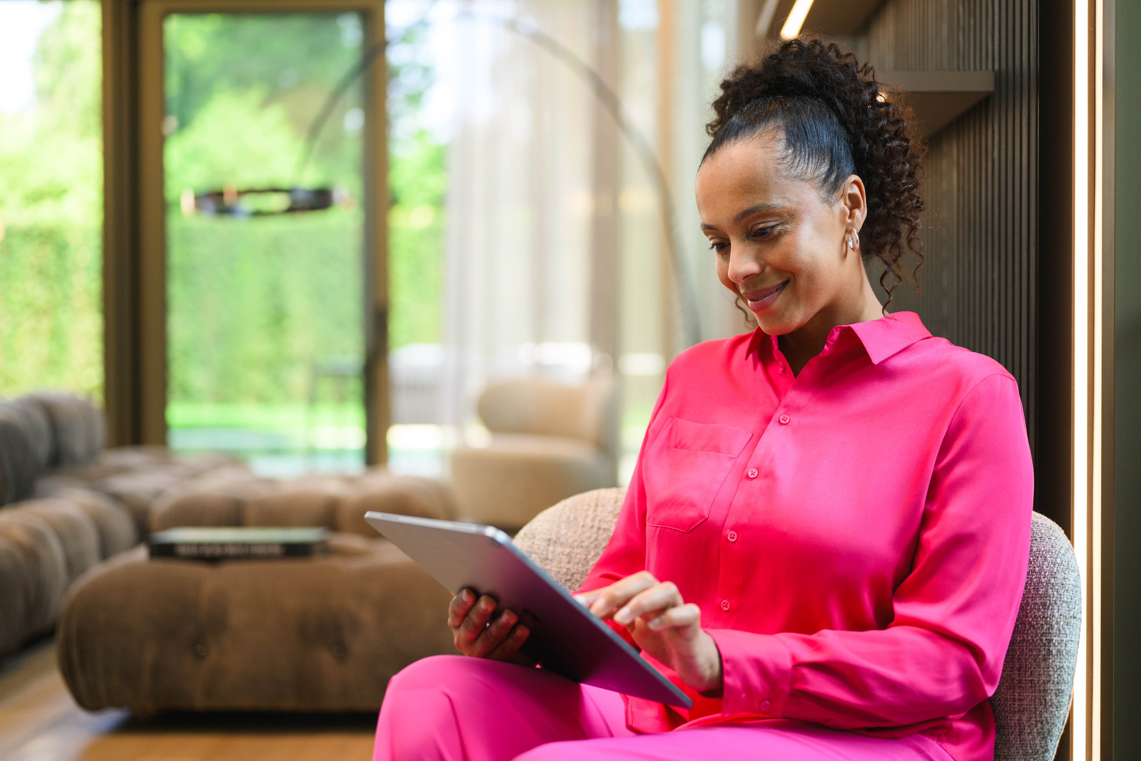 Mercedes-Benz Financial Services im Überblick | Mercedes-Benz Finance Kundenportal Eine Person sitzt mit einem Tablet auf dem Sofa.