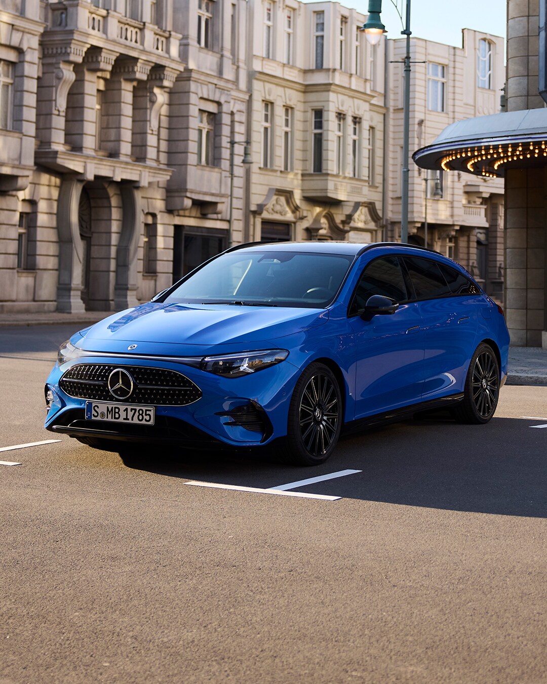 Angebote | Mercedes-Benz Ein leuchtend blauer CLA Shooting Brake vor einer städtischen Kulisse.