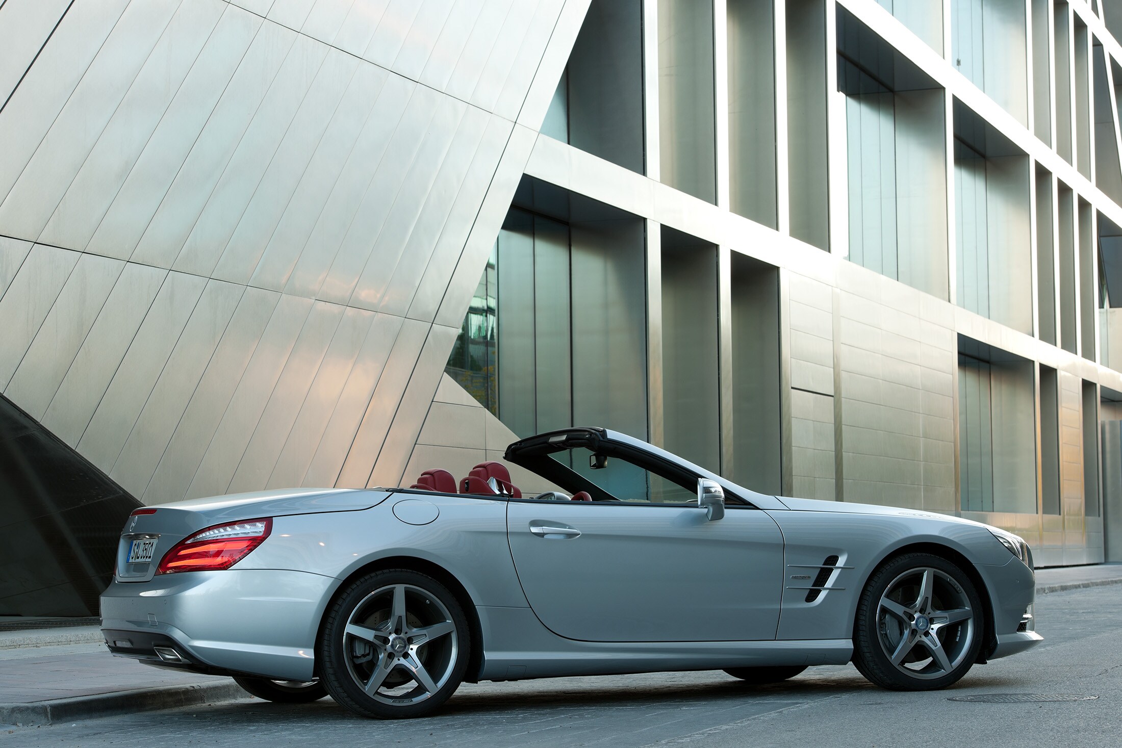 Service- und Garantiepakete | Mercedes-Benz. Ein Mercedes-AMG Cabriolet vor einem futuristischen Gebäude.