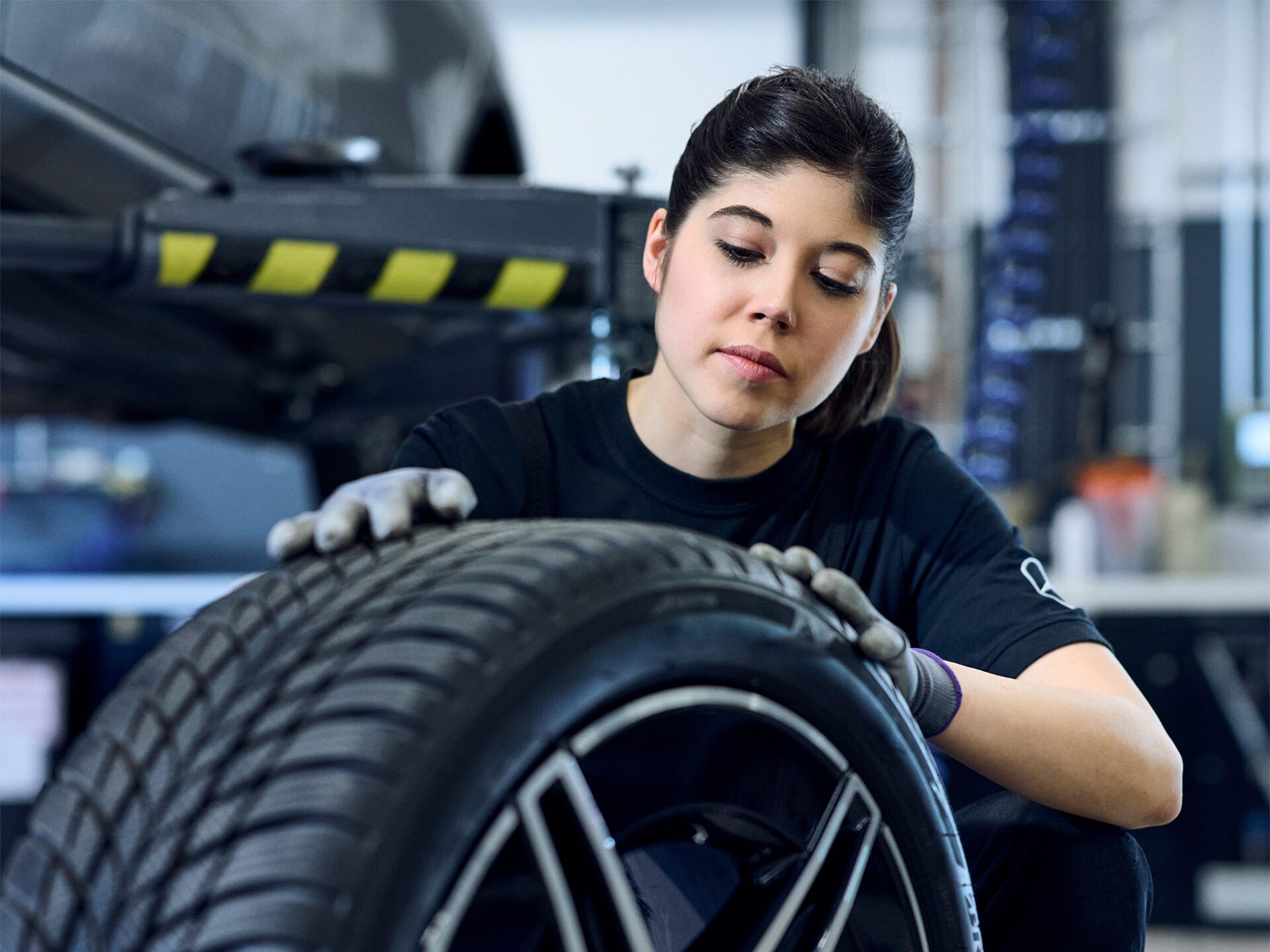 Herbstaktion | Mercedes-Benz Mercedes-Benz Mechanikerin mit Handschuhen an beim Prüfen der Reifenprofiltiefe.