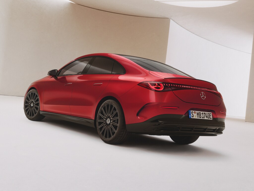 Elektroauto Förderungen | Mercedes-Benz. Seiliche Rückansicht eines roten vollelektrischer Mercedes-Benz CLA, der in einer hellen lichtdurchfluteten Halle steht.