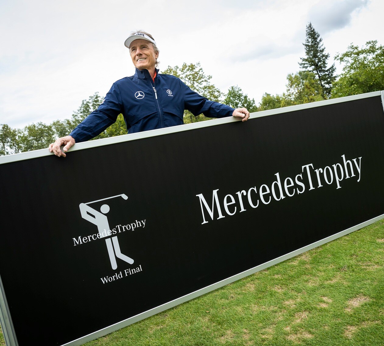 Golf | Mercedes-Benz Ein Mann hält einen Werbebanner mit der Aufschrift "MercedesTrophy".