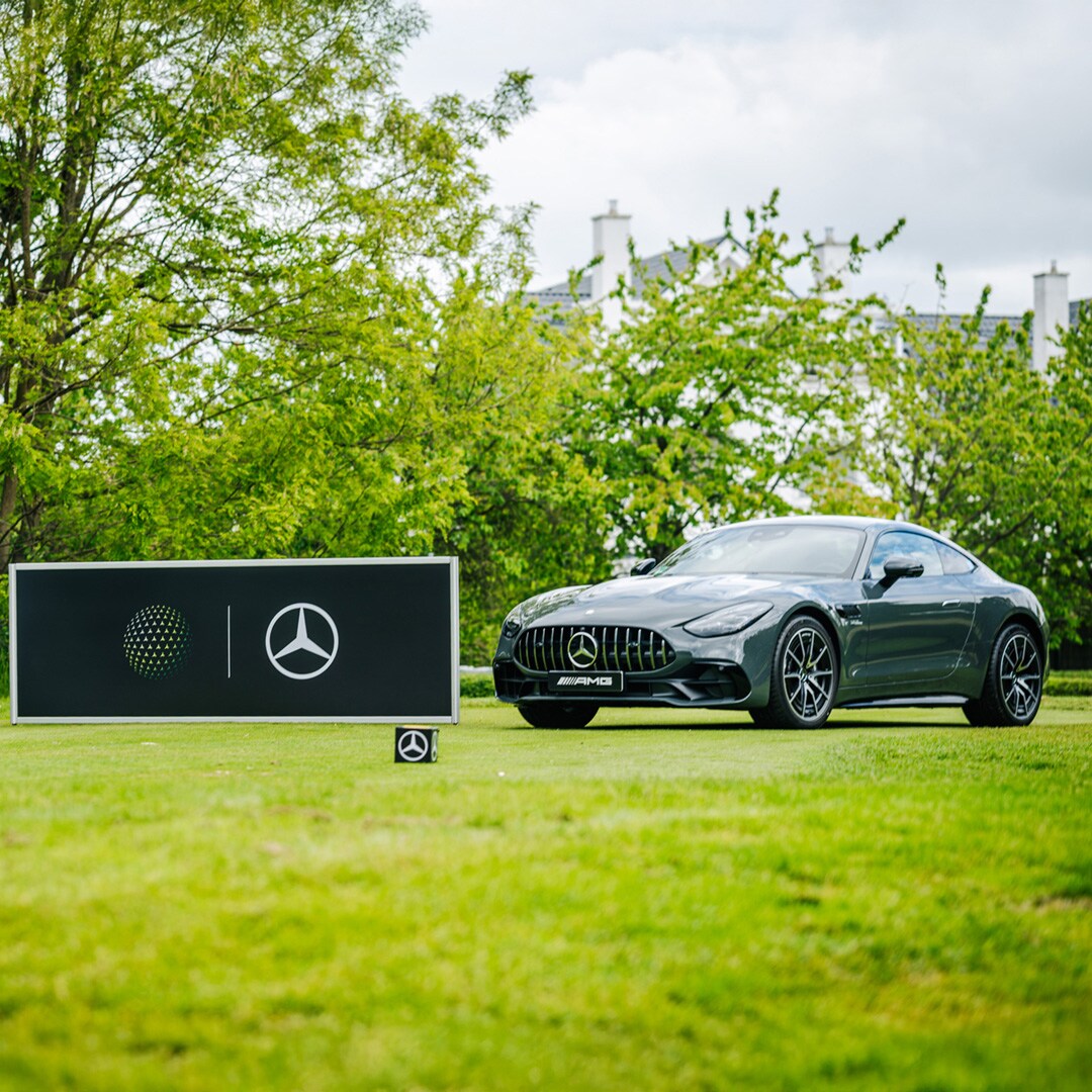 Golf | Mercedes-Benz Ein schwarzes Mercedes-Benz Modell auf grünem Rasen auf einem Golfplatz.