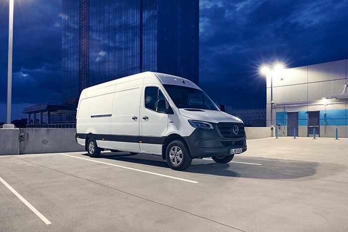 Mercedes-Benz | Tafel-Sponsoring Ein eSprinter Kastenwagen parkt vor einem blauen Hochaus.