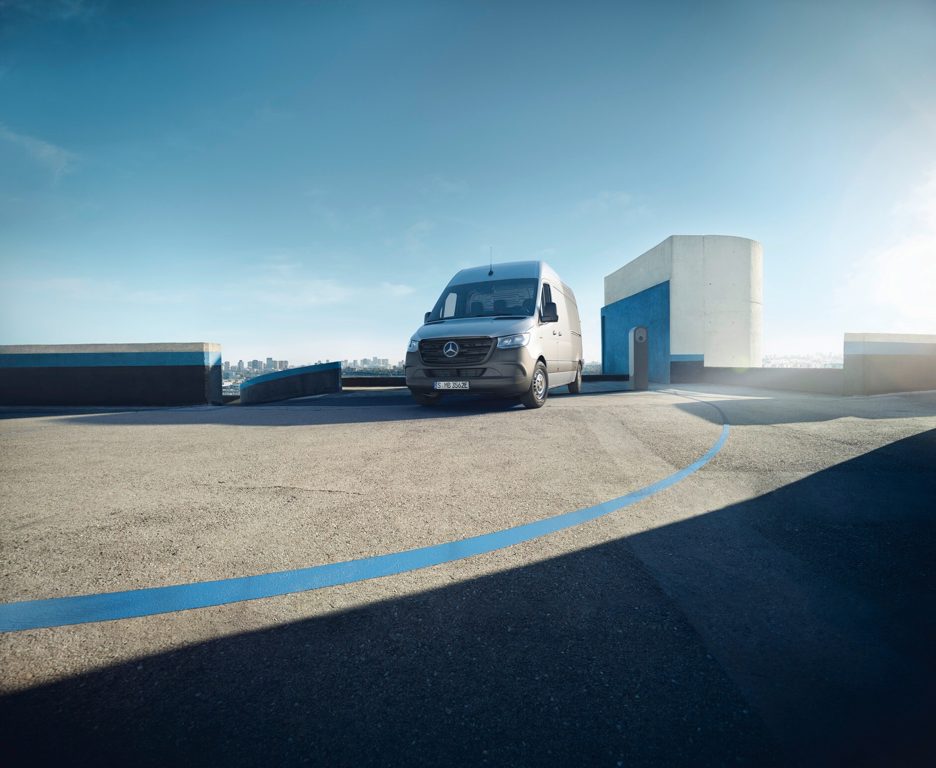 Assistenz- & Sicherheitssysteme | Mercedes-Benz Transporter. Der Mercedes-Benz eSprinter Kastenwagen steht auf dem sonnigen Dach eines Parkdecks.