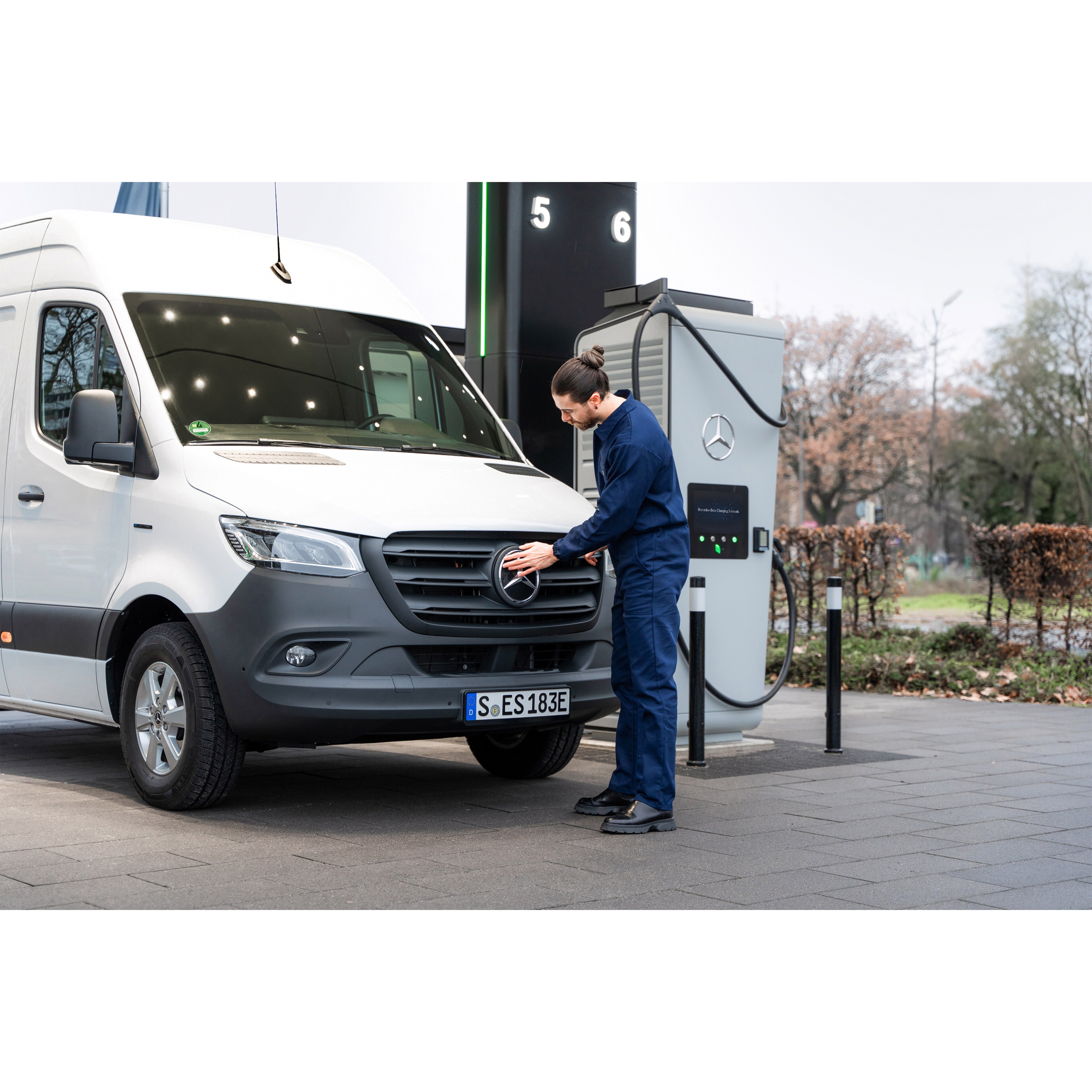Ladelösungen | Mercedes-Benz Transporter. Ein Mercedes-Benz Transporter steht an einer Ladesäule und wird von einem Mann angeschlossen.