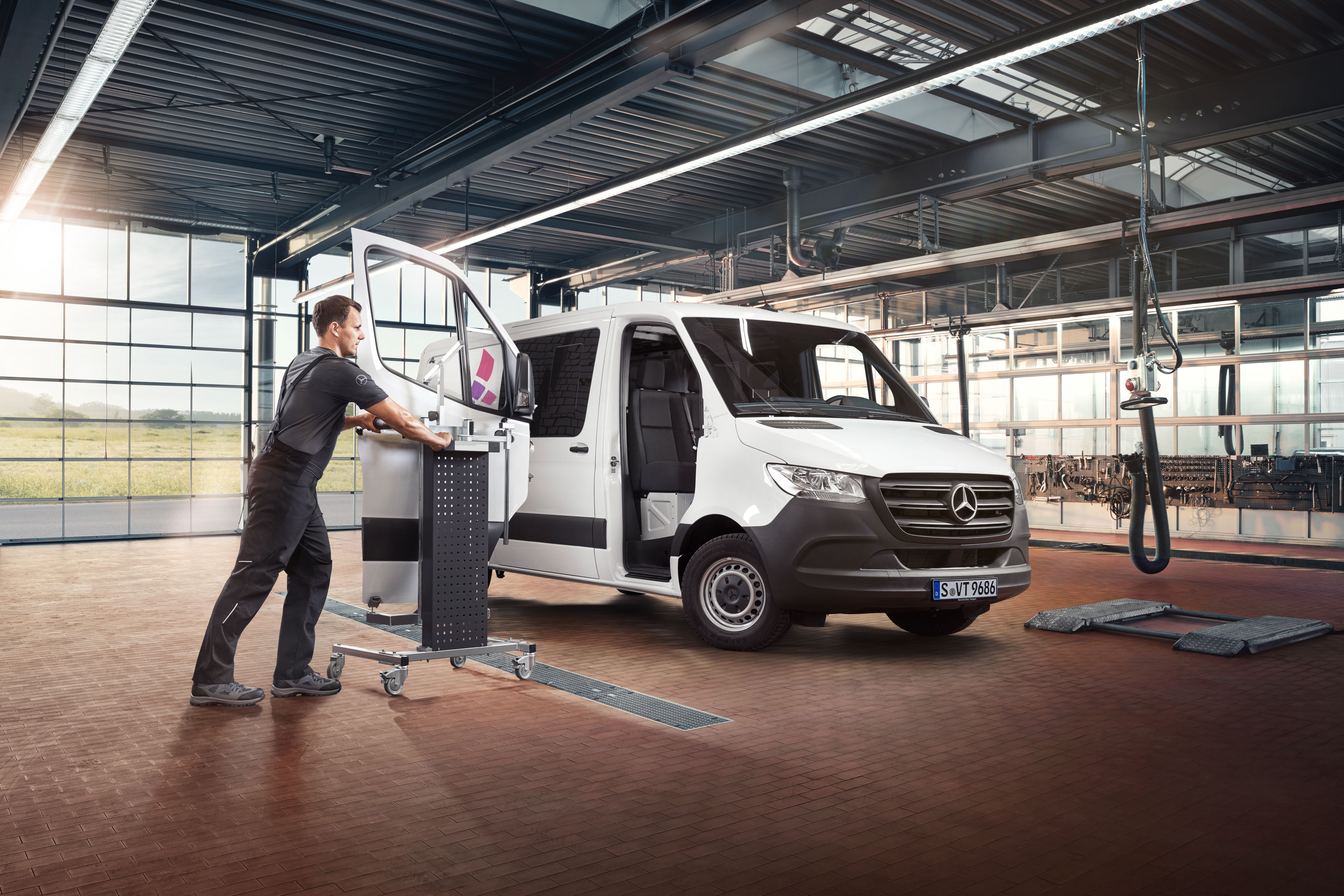 Reparatur | Mercedes-Benz Transporter. Mechaniker bei der Montage der Sprinter-Tür – zuverlässige Karosseriereparatur bei Mercedes-Benz.